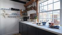 The gorgeous country kitchen is oh-so-pretty with clean white walls, and striking dark blue cupboards