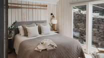 A bedroom filled with natural light and a sumptuous king size bed swathed in luxurious French linens