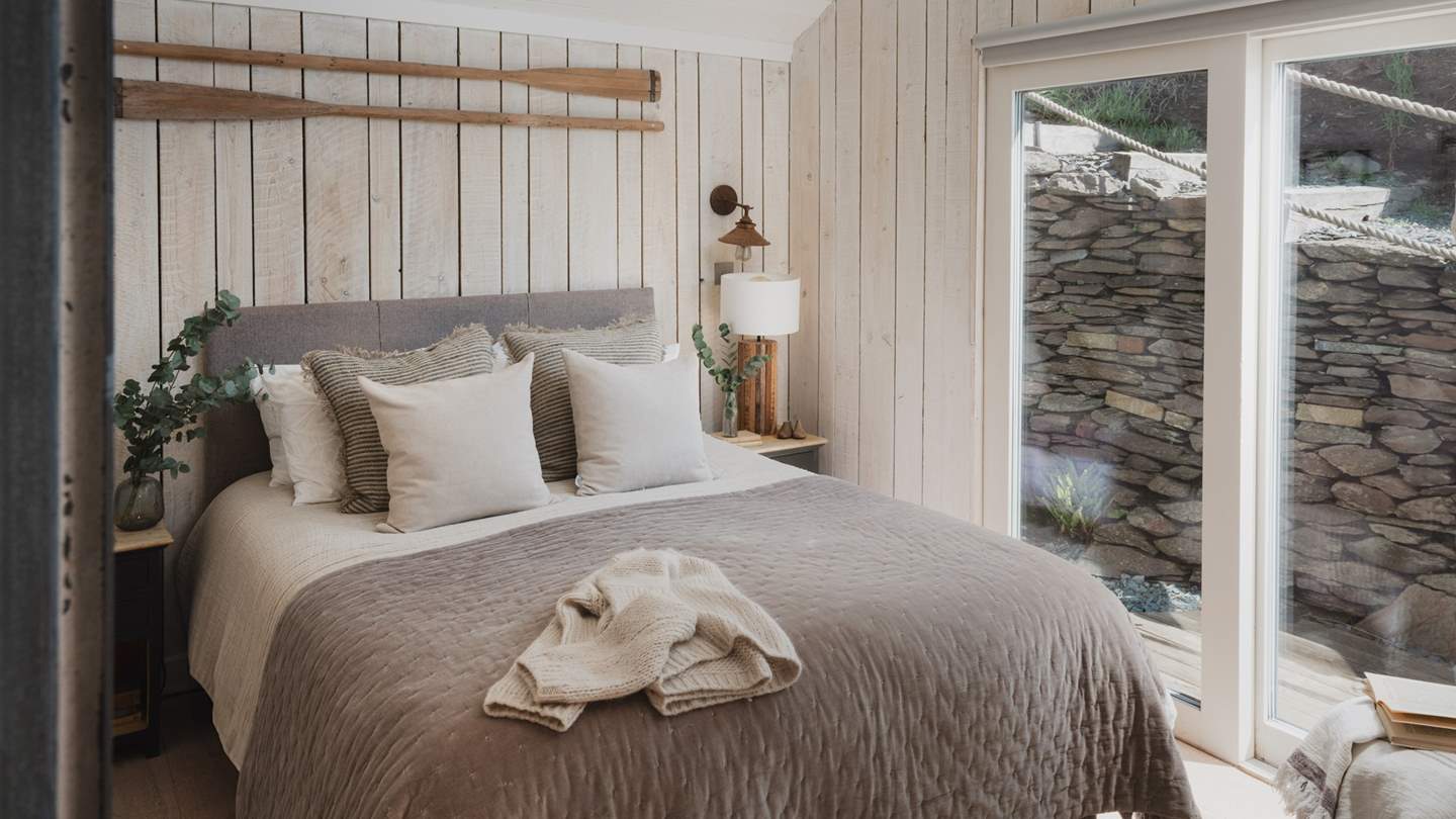 A bedroom filled with natural light and a sumptuous king size bed swathed in luxurious French linens