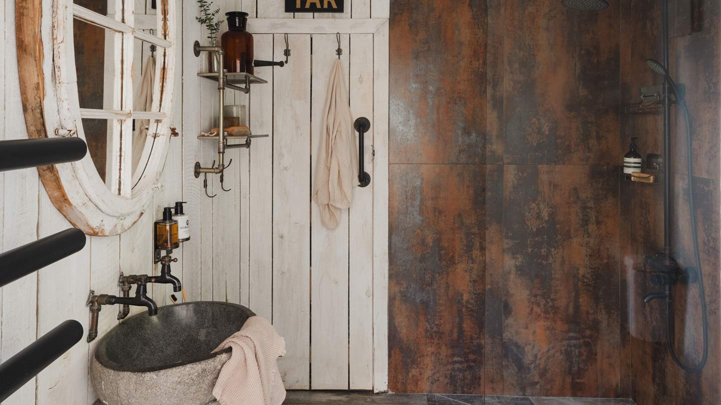 The en suite has a walk-in rainfall shower, gorgeous stone sink and heated rail to keep towels warm and fluffy