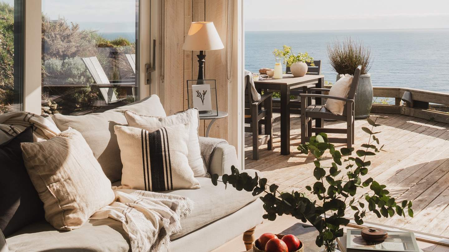 Natural linen sofas, striped cushions, and warm wooden tones, all beautifully reflective of the coastal view you'll find at Verdun