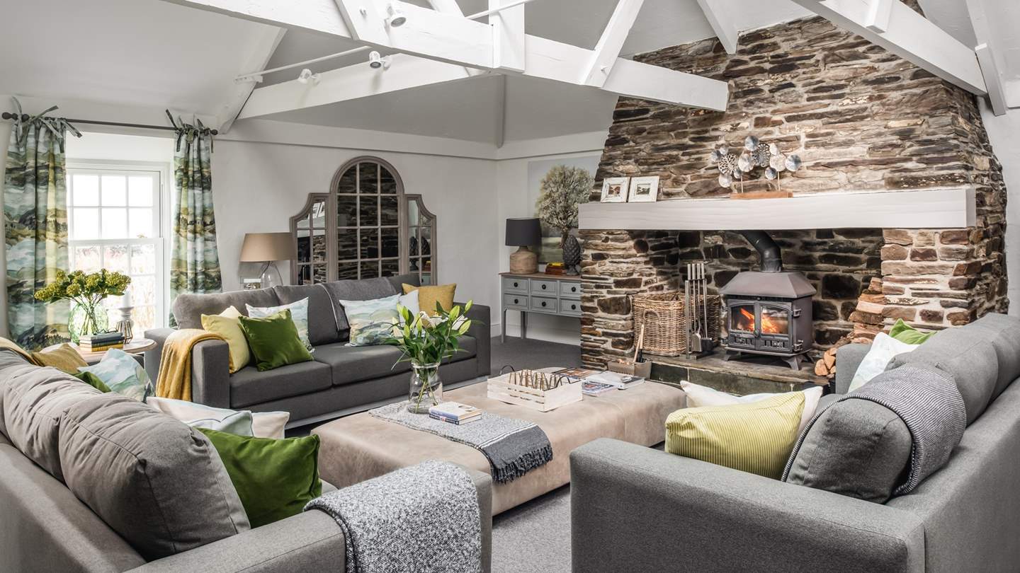 The incredible sitting room is just huge with high vaulted ceiling, sofas that easily seat ten, massive wood burning stove and large coffee table
