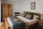 Soothing slumbers reside in the master bedroom, adorned with solid wood furniture and elegant interior details