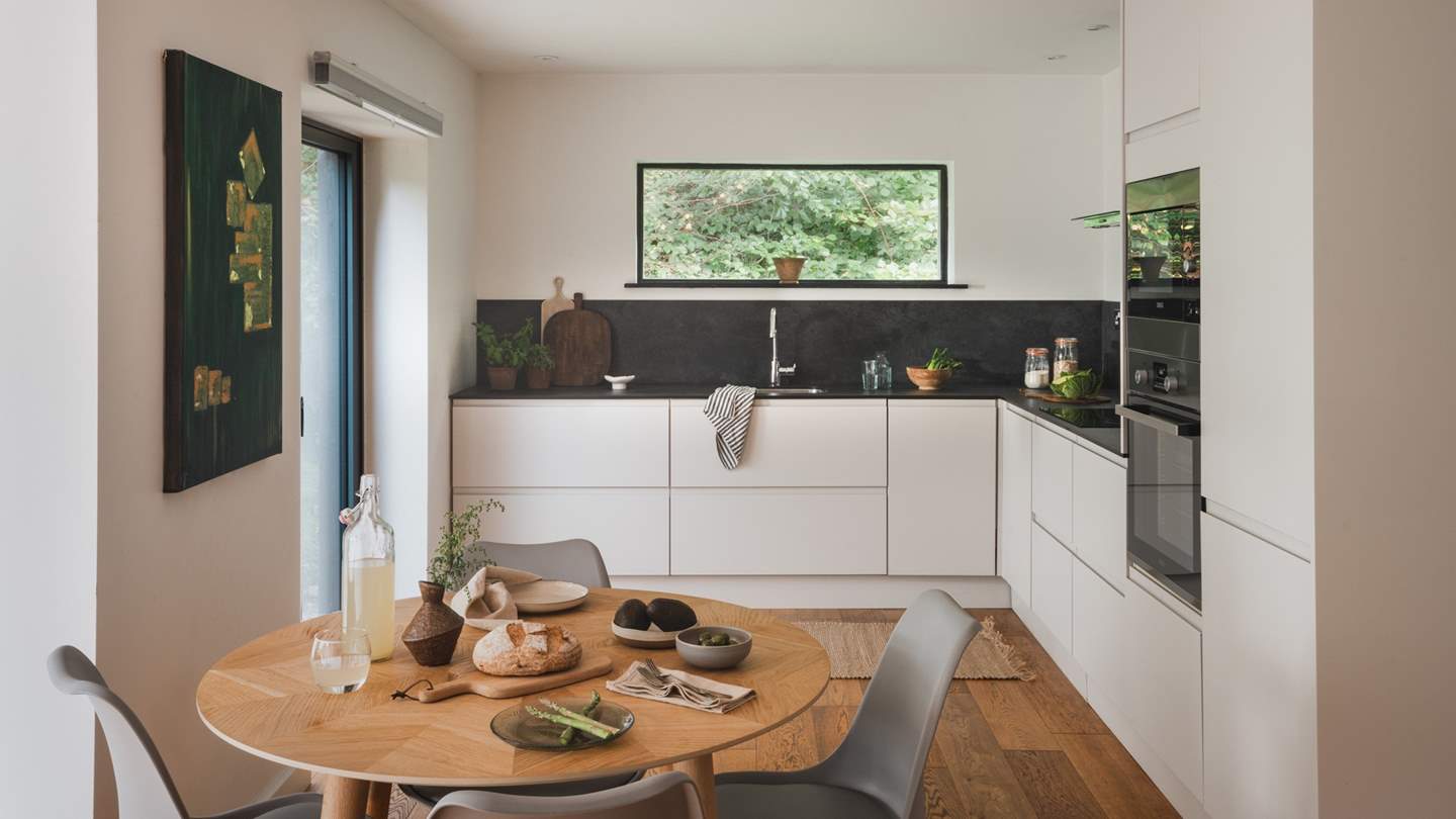 Step into the contemporary kitchen space, promising a sleek black worktop for creating culinary magic