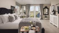 Upstairs, the bedroom to the front of the house is totally glamorous with a sumptuous black velvet king size bed