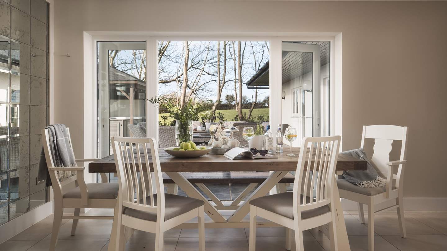 The dining room has an eight-seater dining table which overlooks the garden, with doors that open onto the terrace during warmer months