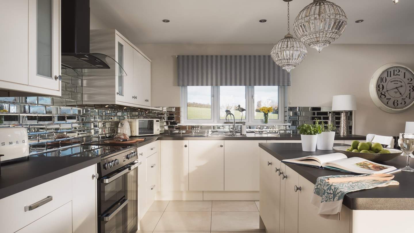 The kitchen is fully equipped with a range oven, ceramic hob, integrated appliances including fridge, freezer and dishwasher