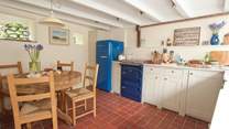 The charming country-style kitchen with original terracotta tiles and rustic wooden table to sit four, lends a sense of celebration to mealtimes at home