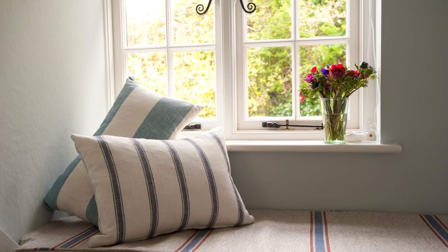 The cute window seat offers a calming corner to cosy up with your favourite book