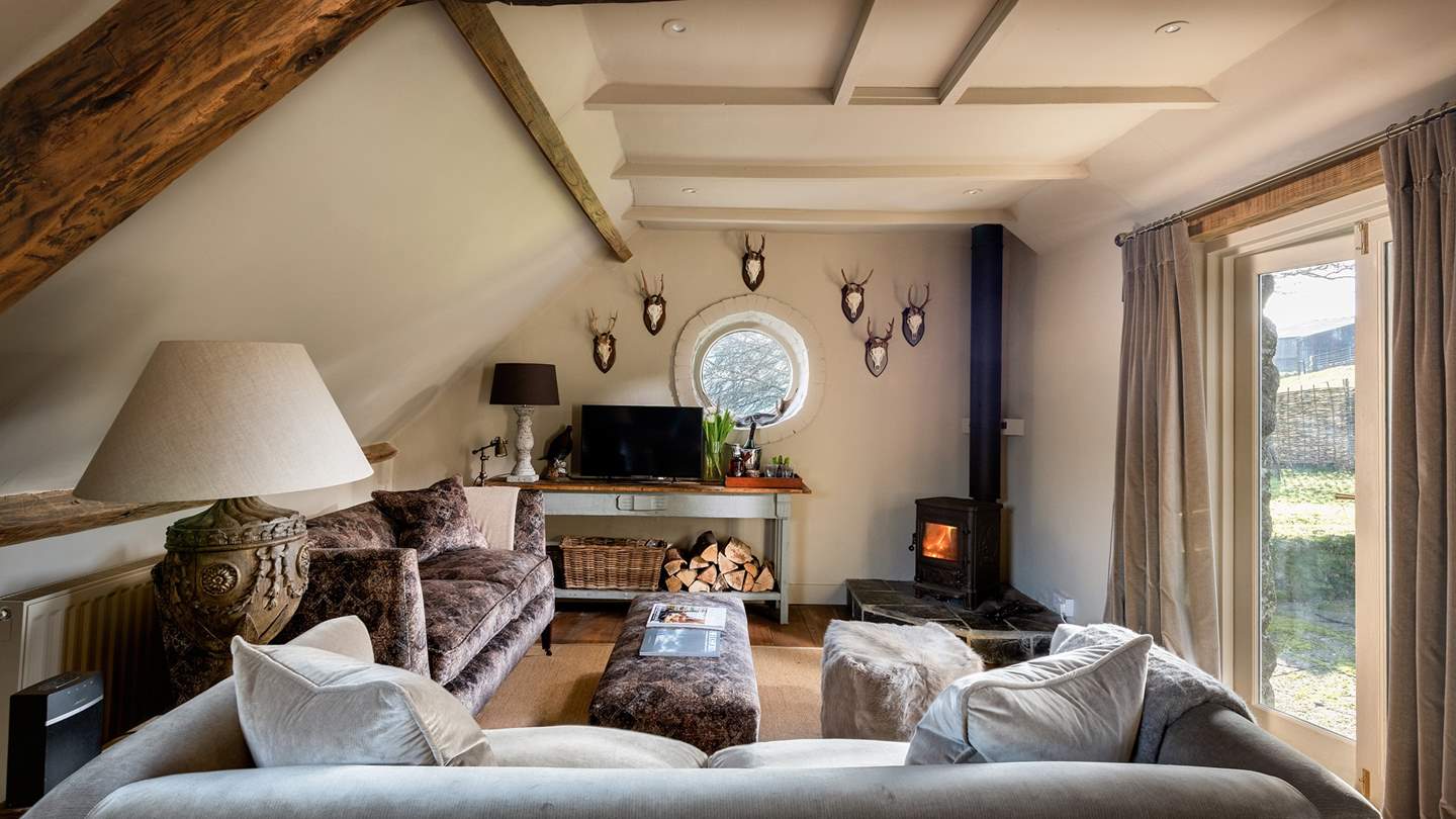 The pretty sitting room and wood burner is the perfect spot for lazy afternoons or evenings curled up on the sofas.