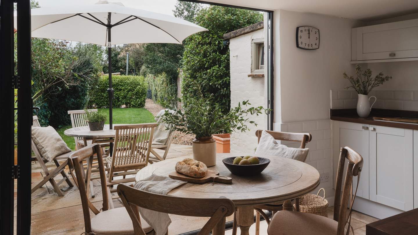 Large glass bi-folding doors open up to the sheltered garden allowing the space to fill with plenty of natural light