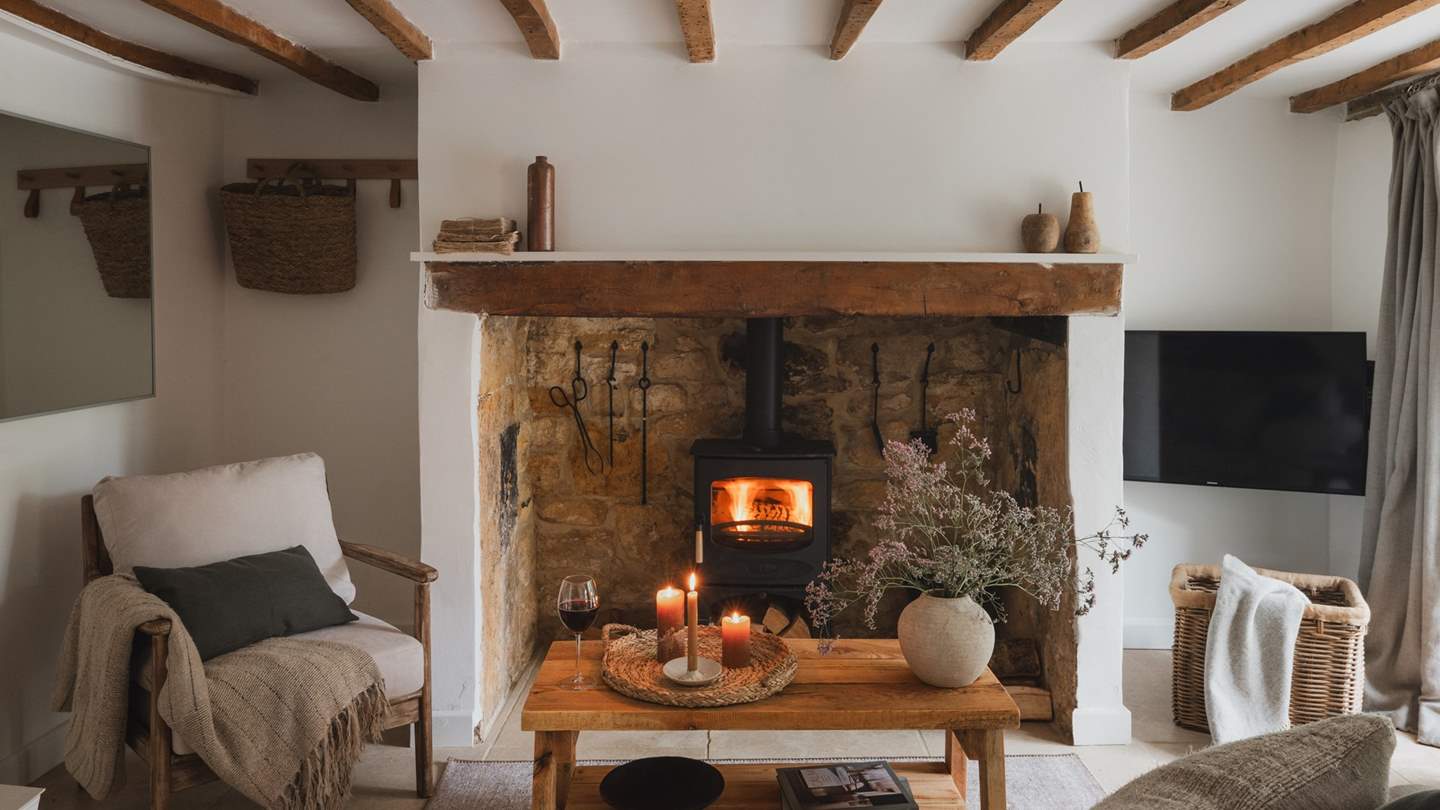 A gorgeous wood burning stove rests sweetly in a large inglenook fireplace for snug moments spent fireside