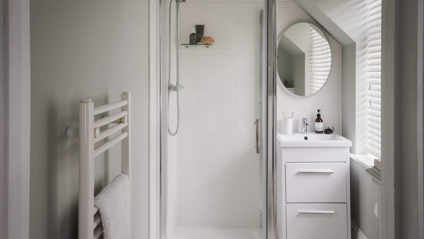 An ensuite bathroom in white completes this bedroom, elegantly finished with a walk-in shower
