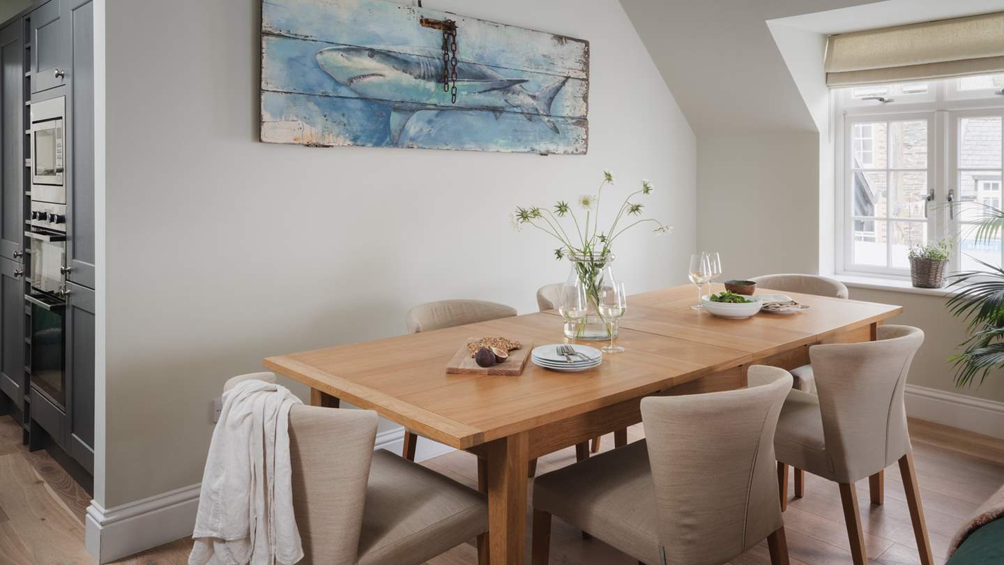 To savour meals together, a wood dining table resides beneath the apex ceiling of the open-plan living area