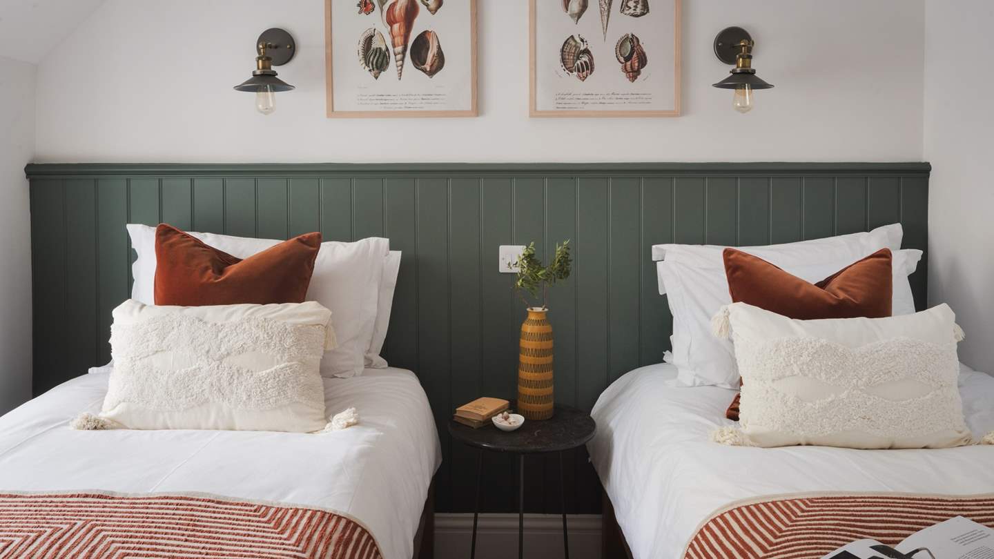 Imbuing timeless charm, it features white walls complemented with forest green wainscoting, paired with vintage brass and black wall lanterns