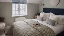Welcoming for the most serene slumbers, the first bedroom exudes peace in tones of sage and white