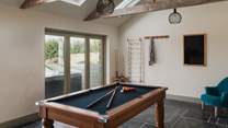Next to the hot tub lies the games room, accessed by one step, which comes complete with a pool table, wine fridge and Sonos speaker to keep everyone entertained