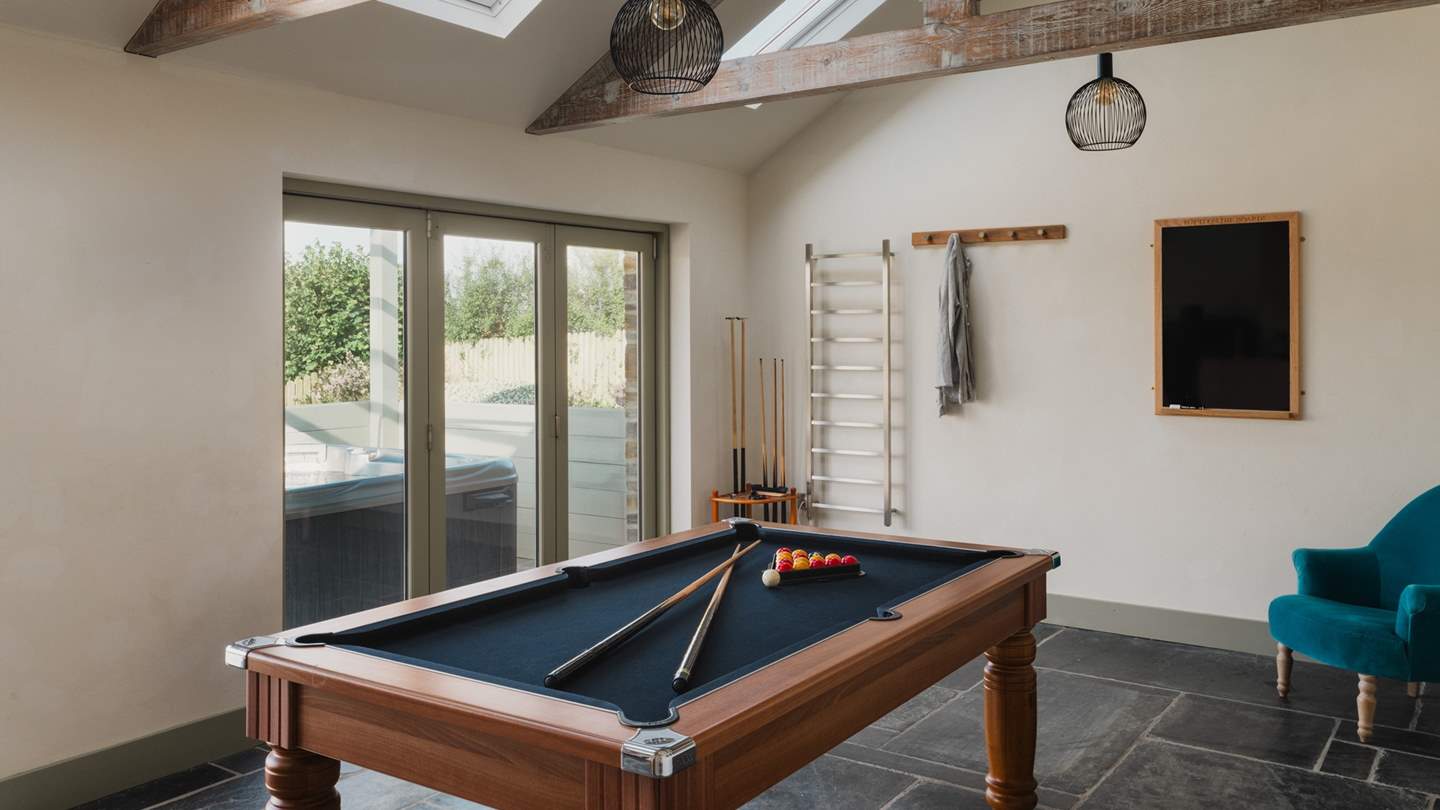 Next to the hot tub lies the games room, accessed by one step, which comes complete with a pool table, wine fridge and Sonos speaker to keep everyone entertained