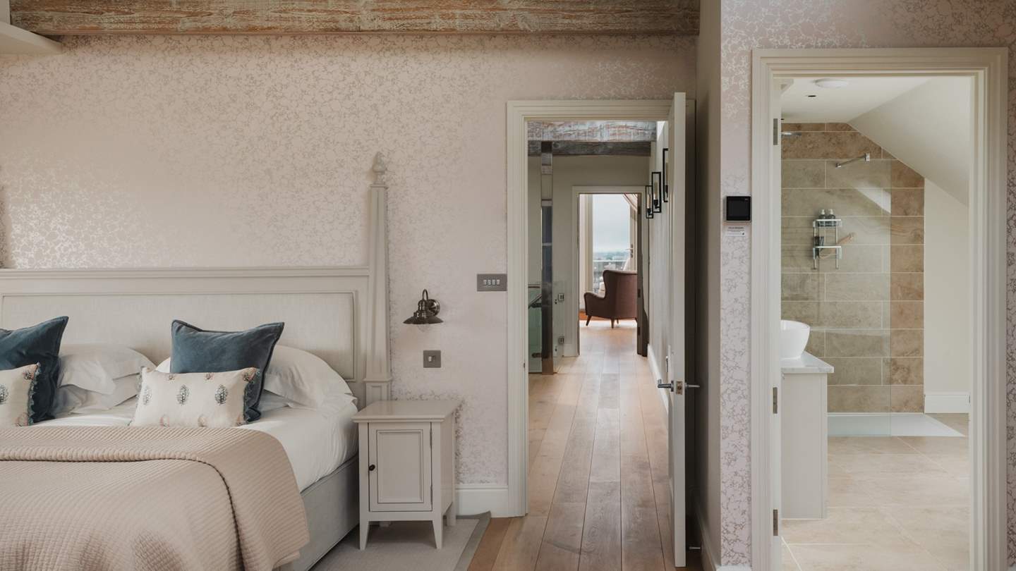 A light-filled bedroom with triple-aspect windows and bespoke fitted wardrobes