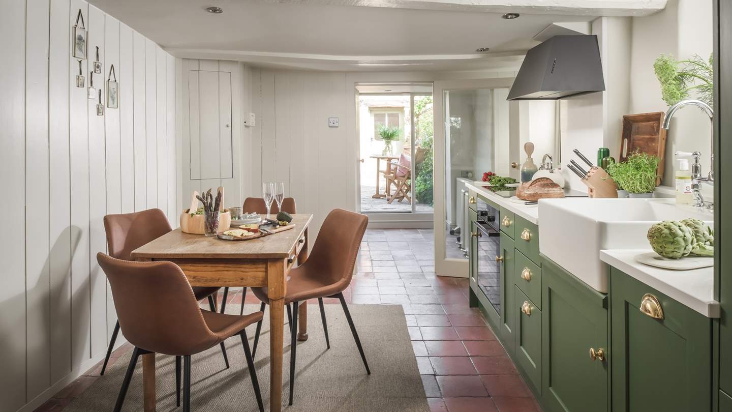 The stylish shaker kitchen is ever so inviting with its terracotta tiled flooring, hand-painted John Lewis of Hungerford cupboards