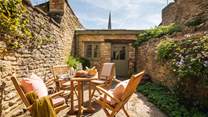 Leading out from the kitchen is a lovely, sunny walled courtyard garden where clematis and vines climb the sandstone walls, offering plenty of privacy