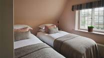 The second, smaller bedroom, in glorious shades of dusky pinks and greys, has a zip-and-link bed meaning it can be made into twins or a super king bed