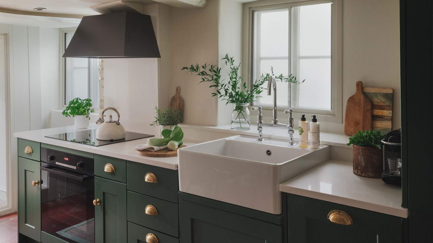 The stylish shaker kitchen is ever so inviting with its terracotta tiled flooring, hand-painted John Lewis of Hungerford cupboards