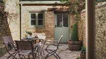 Leading out from the kitchen is a lovely, sunny walled courtyard garden where clematis and vines climb the sandstone walls, offering plenty of privacy