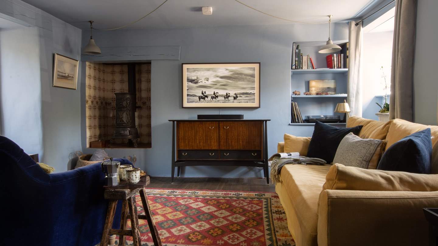 We just love the Rasmussen woodburning stove flickering against the stunning antique tiles...