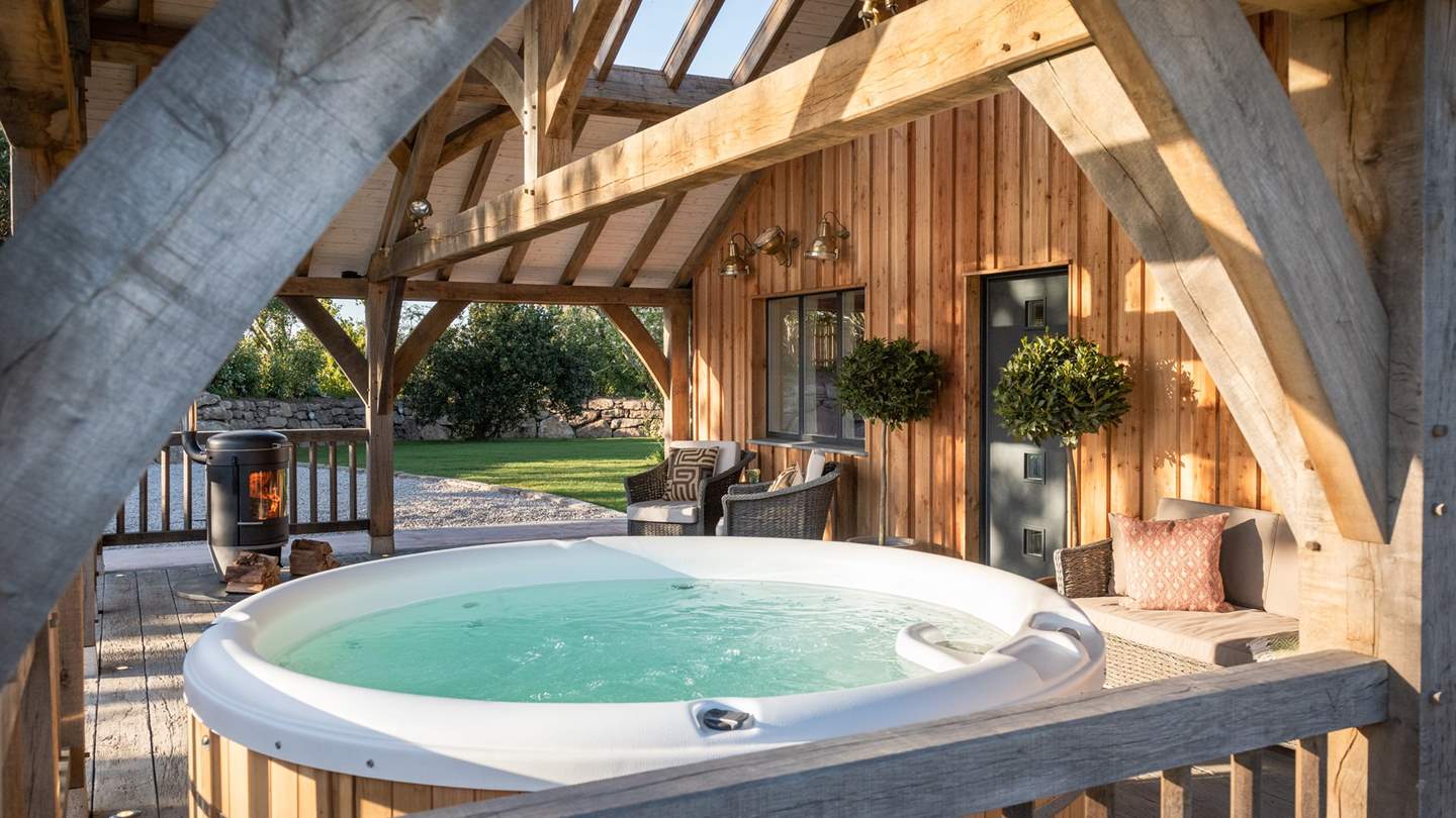 Sheltered underneath Dawnsmen's pergola lies a gorgeously bubbling hot tub, outdoor Chesney wood burner and barbeque