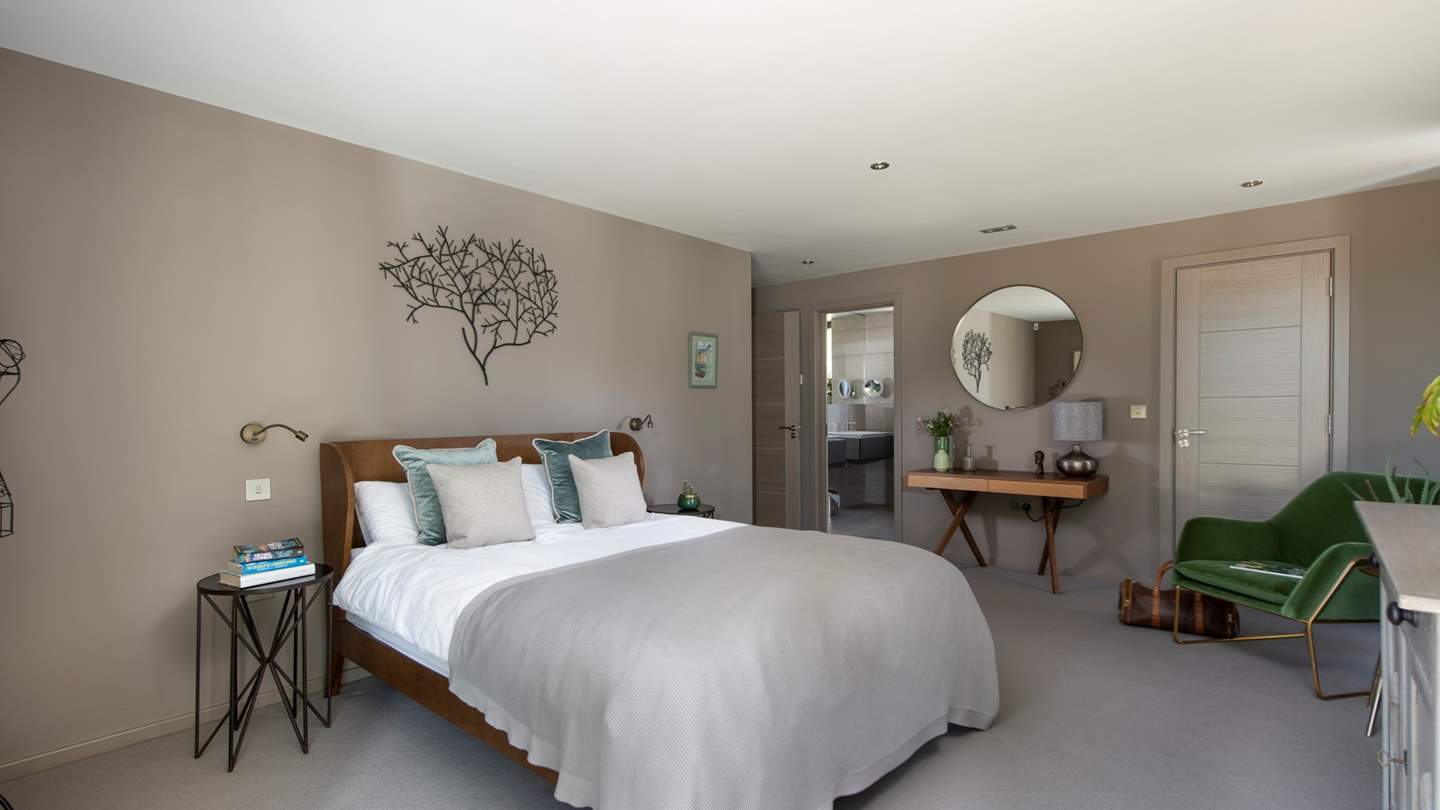 This gorgeous en suite bedroom is just lovely - we particularly like the green velvet chair