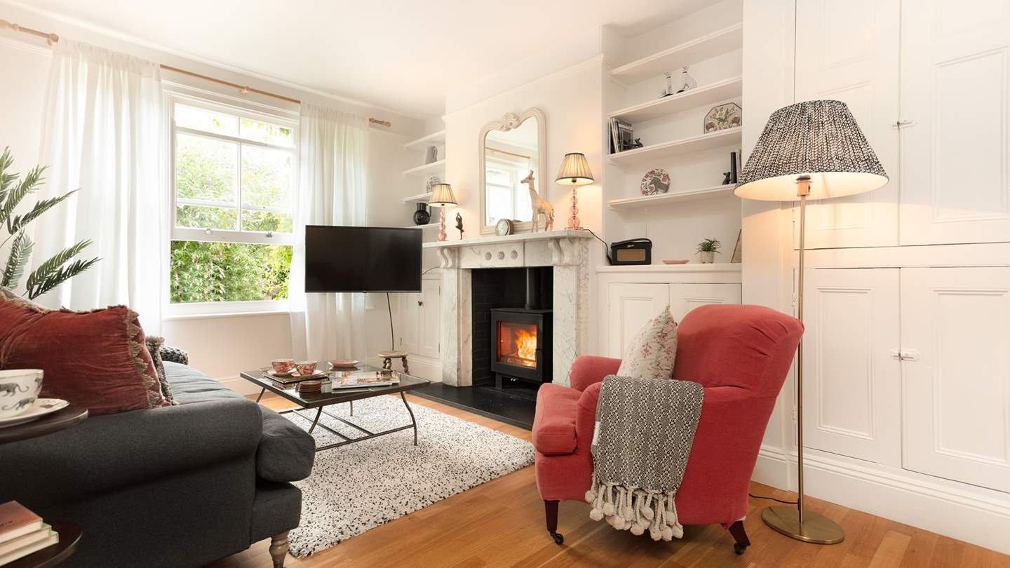 The sitting room lies to the front of the house and is a pretty, cosy spot with a striking marble fireplace and a fabulous wood burning stove