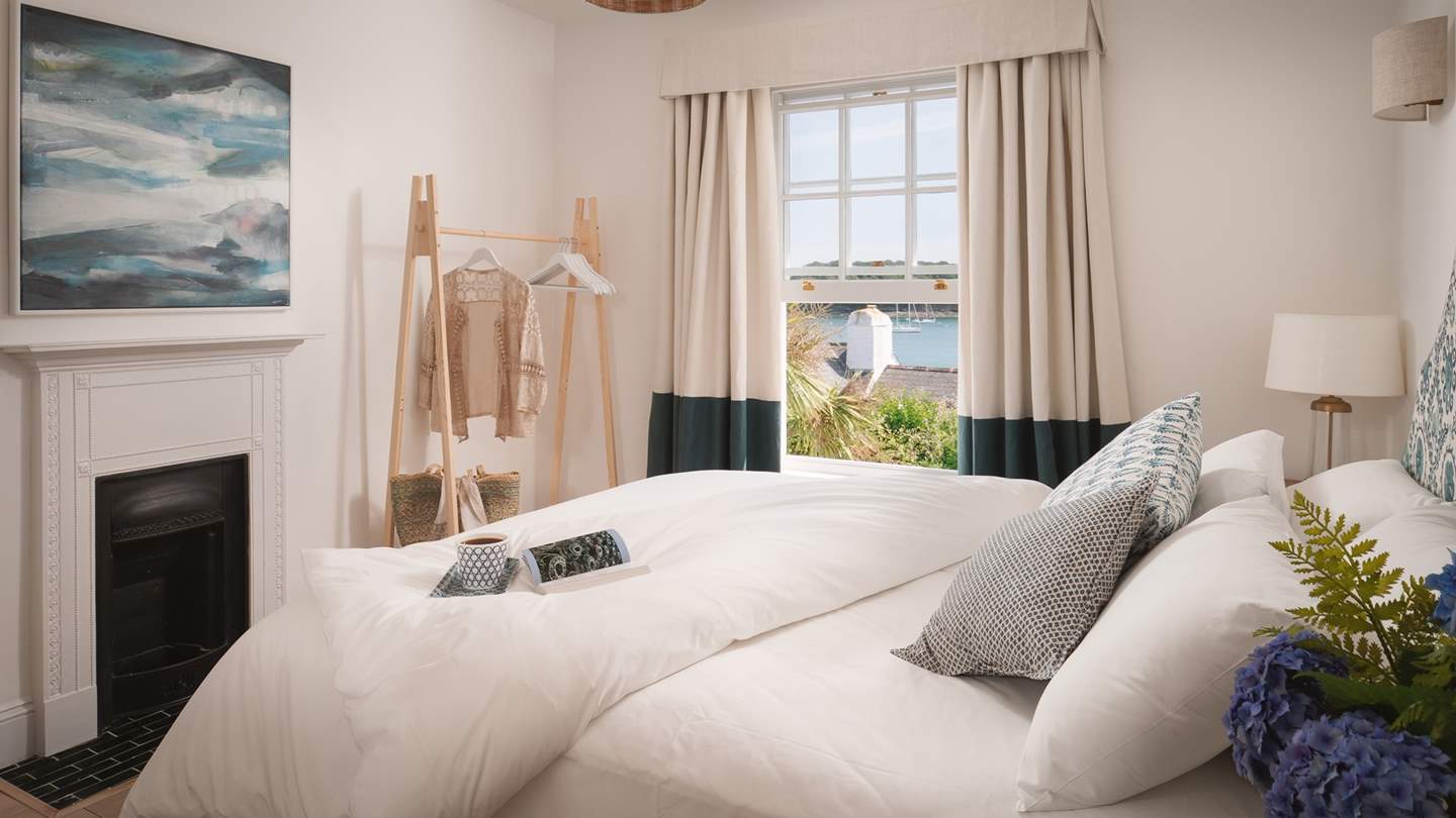 The master bedroom on the first floor has a super-comfy king bed, wonderful sea views and the eye-catching original fireplace