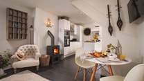 To the right of the fire lies the modern, stylish kitchen with black granite worktops and sleek white cupboards