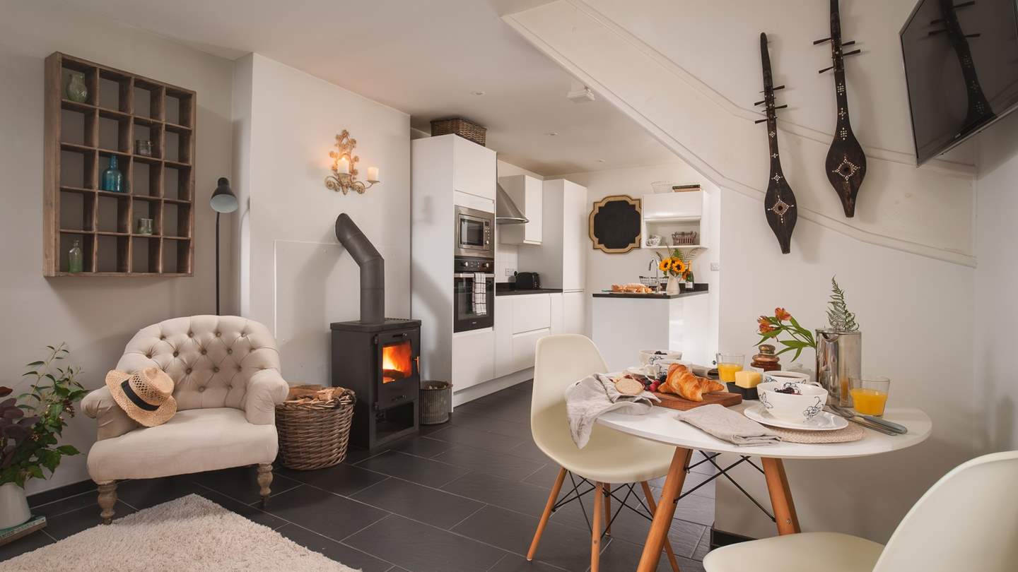To the right of the fire lies the modern, stylish kitchen with black granite worktops and sleek white cupboards