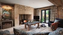 The large, striking sitting room is beautiful with exposed stone walls, original  flag floors, wooden beam and large fire with wood burning stove