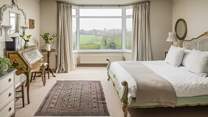 Up stairs is stunning bedroom with views over the gardens to the sea beyond.