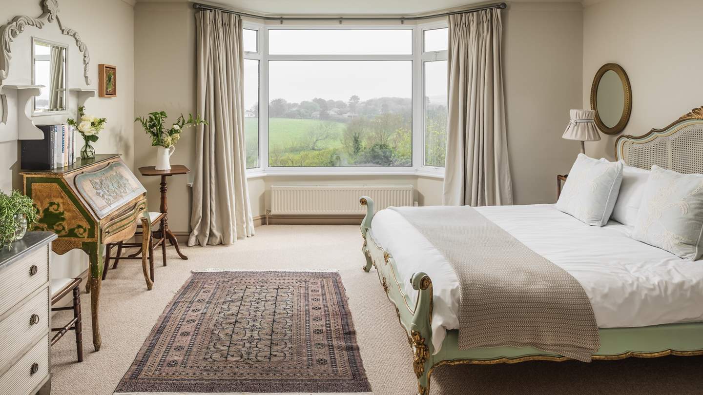 Up stairs is stunning bedroom with views over the gardens to the sea beyond.