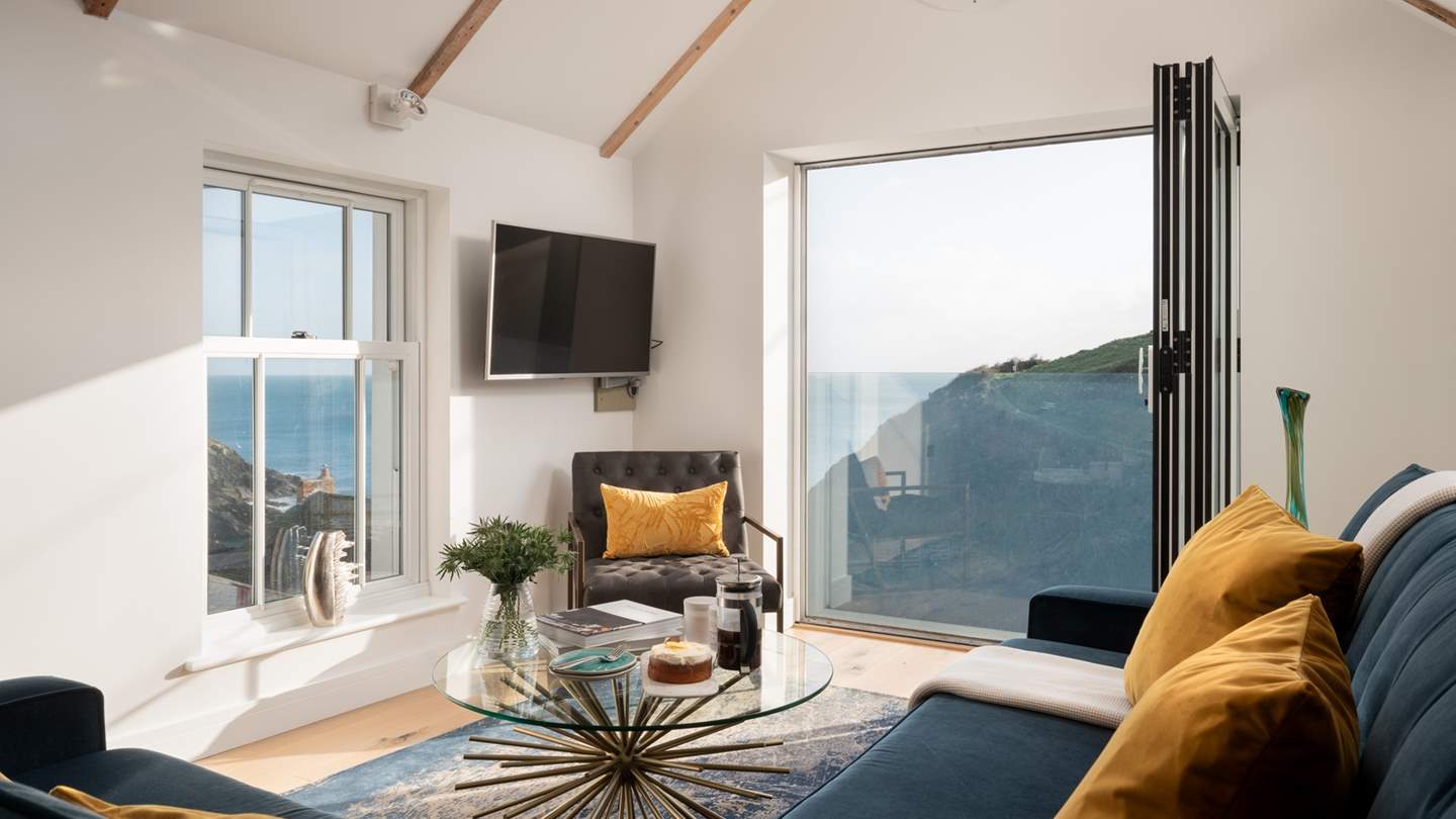 Bi-fold windows at the far end of the room can be pulled back on warmer days to let the blissful sea breezes in