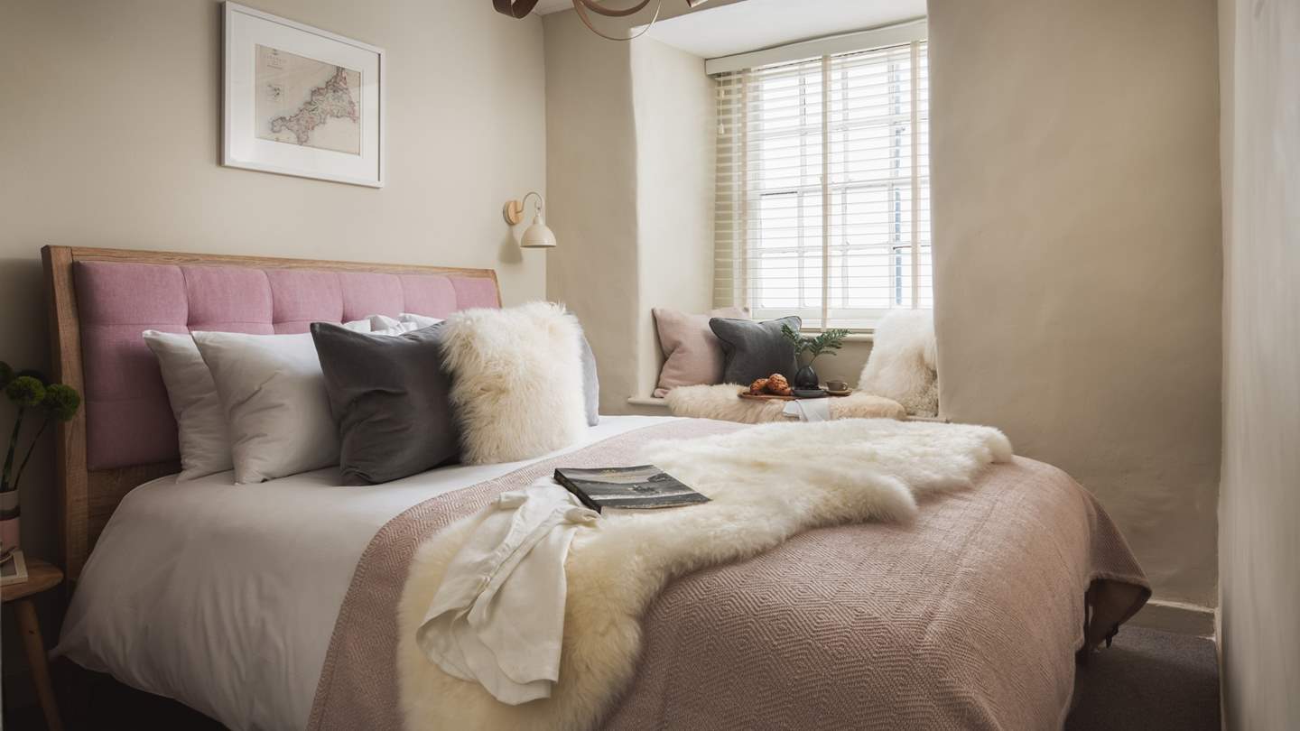 The master bedroom is super-pretty with a sumptuous king size bed with dusky pink headboard