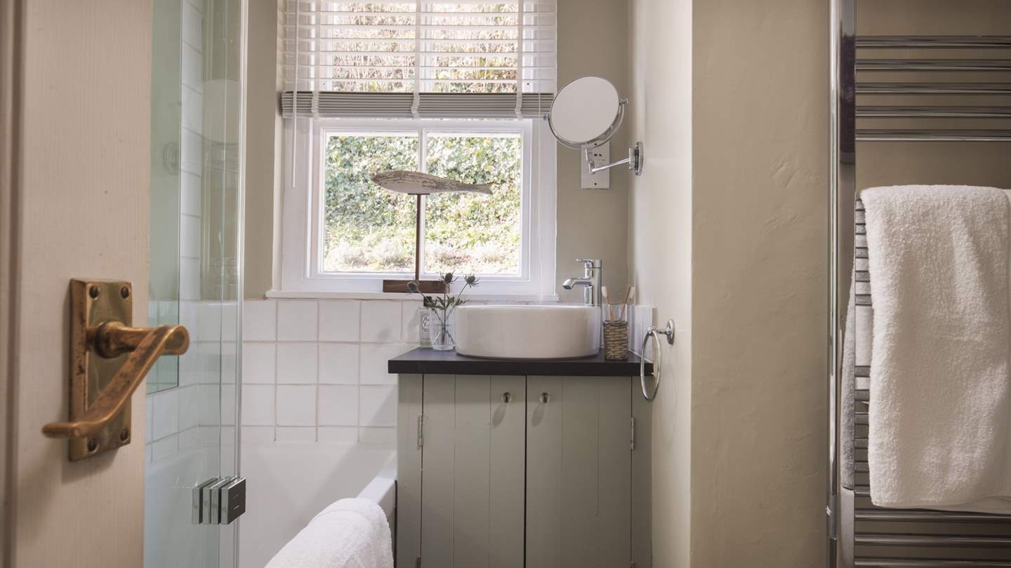 The pretty bathroom boasts a large bath for soaks and an overhead shower to wake you up in the morning