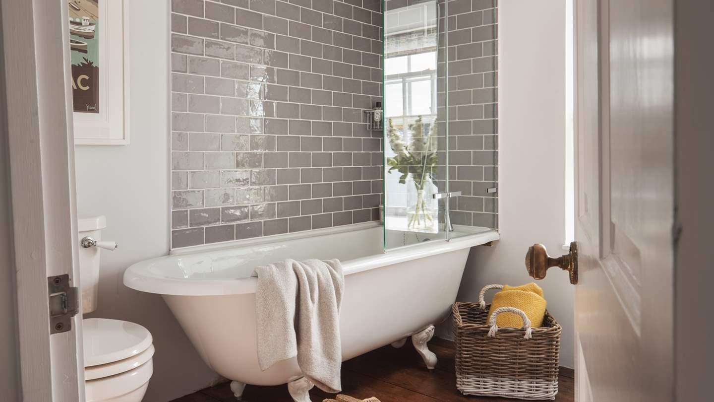 The pretty bathroom boasts a deep free-standing bath with a shower overhead