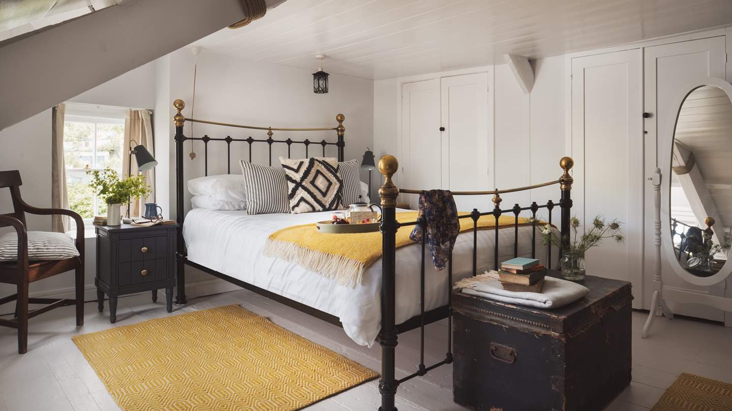 We adore the bed knobs-and-broomsticks king size bed, swathed in luxurious linens, throws and cushions 