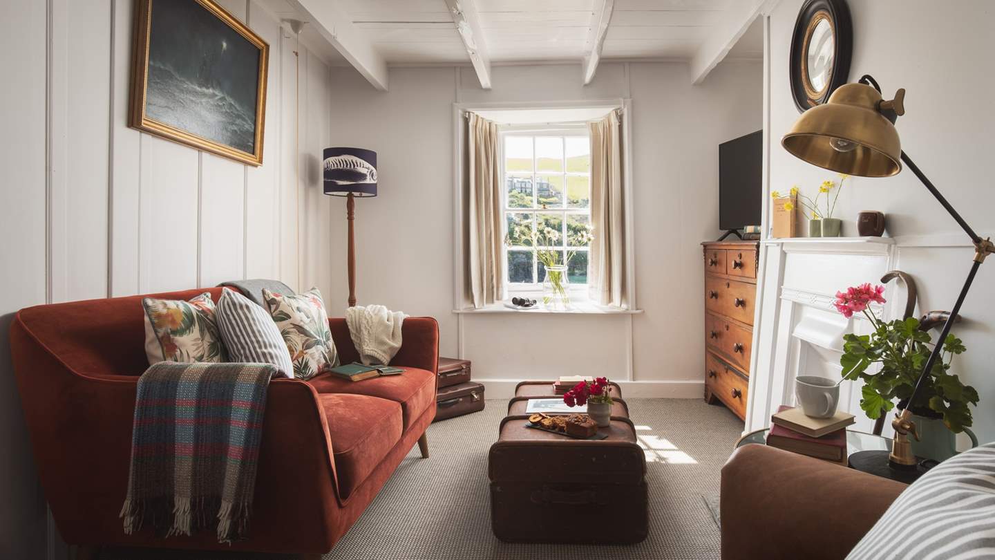 Super-cosy, the pretty sitting room is serene and welcoming, with its original pale wooden panelling and beamed ceiling