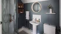 A stunning en suite shower room in soft grey and blue hues with a heated rail to keep towels warm and fluffy