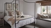 The oh-so-romantic second bedroom is just divine with a White Company king size four-poster bed
