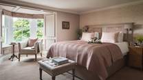 Dusky pinks infuse this bedroom with deeply romantic overtones, and we just love the bay window