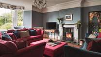 Just wow! The stunning sitting room in jewel tones is the perfect setting for ultimate relaxation around the wood burner