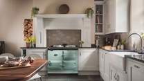 The glorious kitchen, with the mint-coloured electric Aga, is a fabulous mix of traditional country and chic modern kitchen design