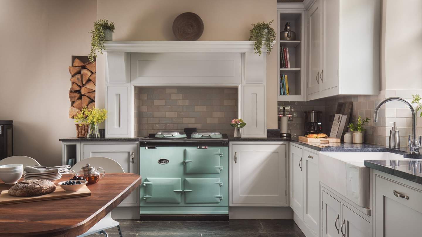 The glorious kitchen, with the mint-coloured electric Aga, is a fabulous mix of traditional country and chic modern kitchen design